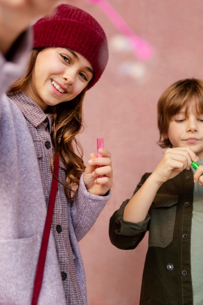 Boy and girl playing with soap bubbles