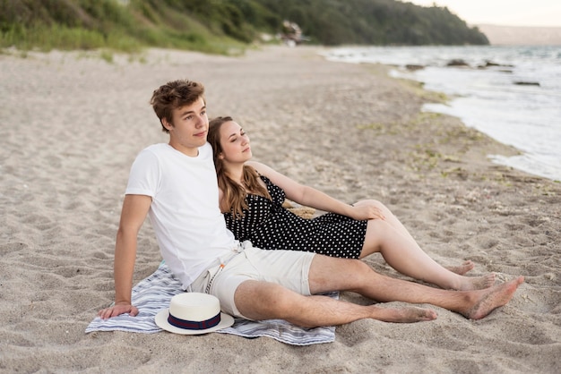 Boy and girl staying together on the beach