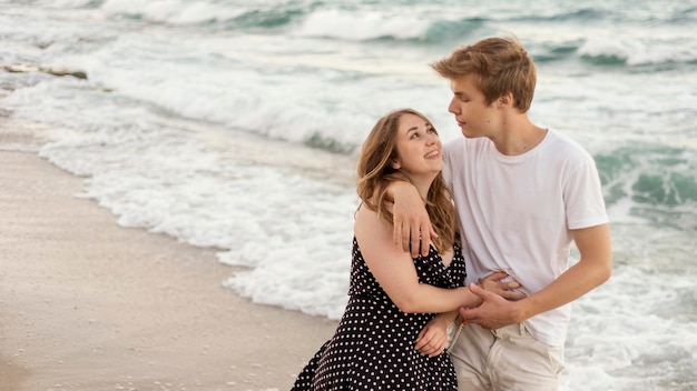 Boy and girl taking a walk together on the beach with copy space