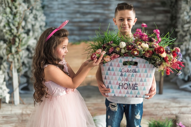 Boy giving bag with flowers to amazed girl in bunny ears