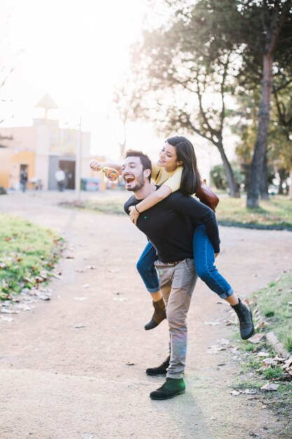 Boy giving a piggy back ride to his girlfriend