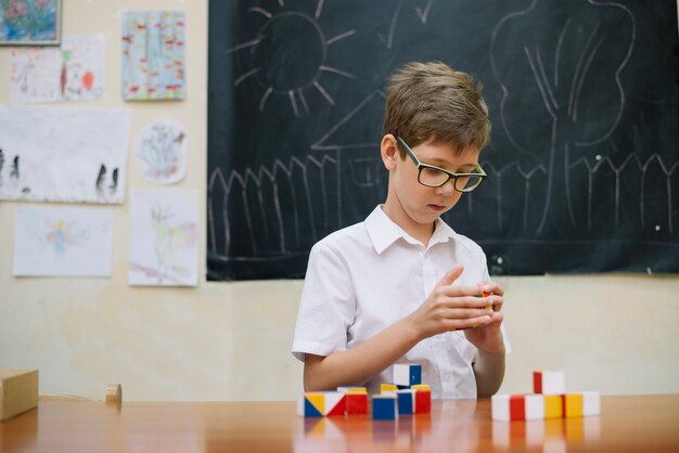 Boy in glasses solving puzzle