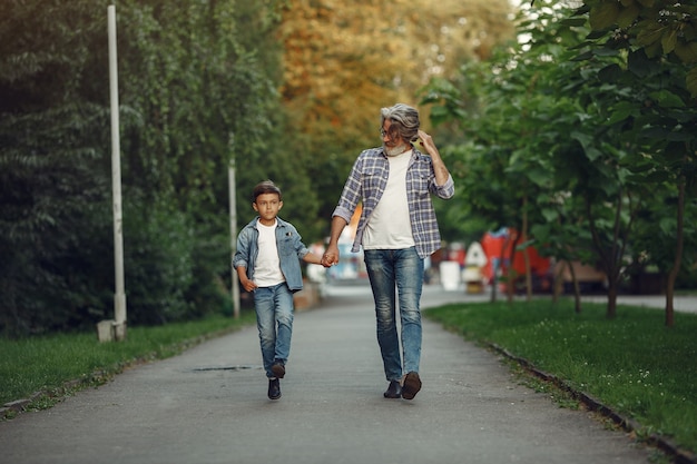 Il ragazzo e il nonno stanno camminando nel parco. uomo anziano che gioca con il nipote.