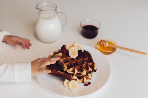 Boy hand touching waffle