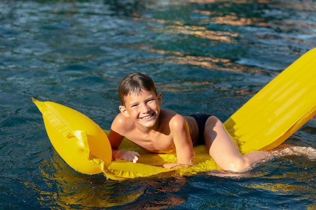 Мальчик веселится в бассейне с поплавком