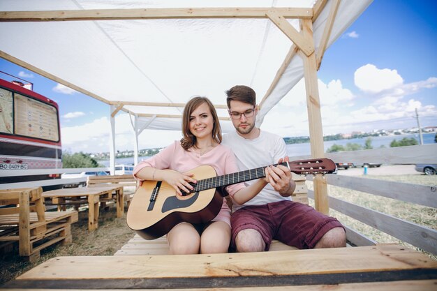 Boy helping a girl to play the guitar