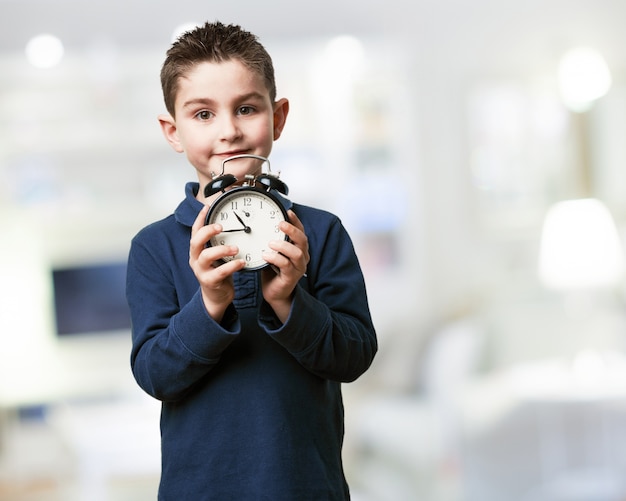 Boy holding an alarm clock