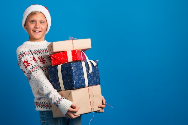 Бесплатное фото Мальчик держит рождественские подарки