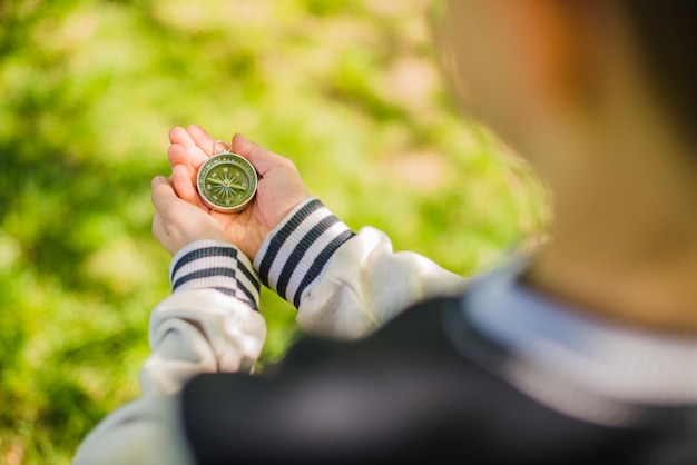 Free photo boy holding a compass in the park