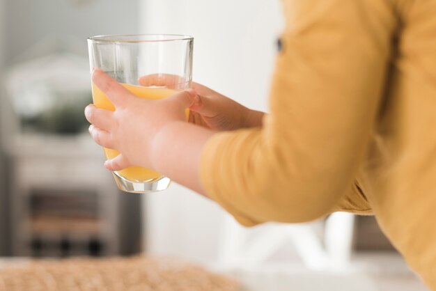 Boy holding glass of orange juice