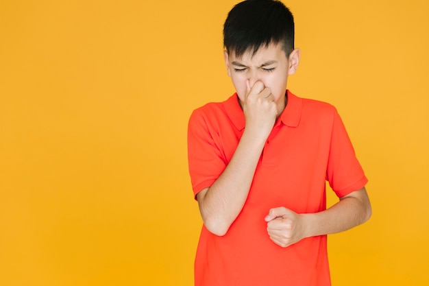 Boy holding his nose because of something stinky