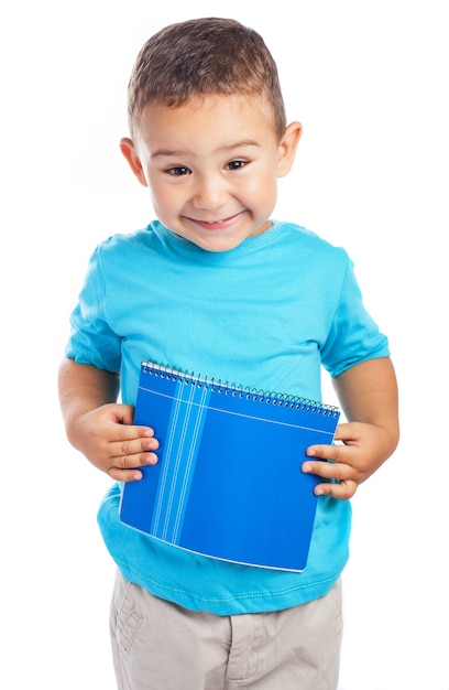 Boy holding a notebook against his belly