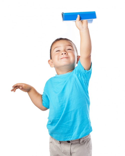 Boy holding a notebook up