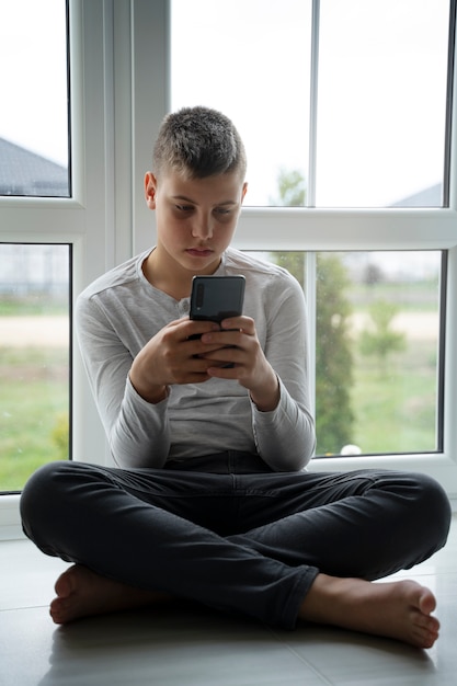 Boy holding smartphone front view