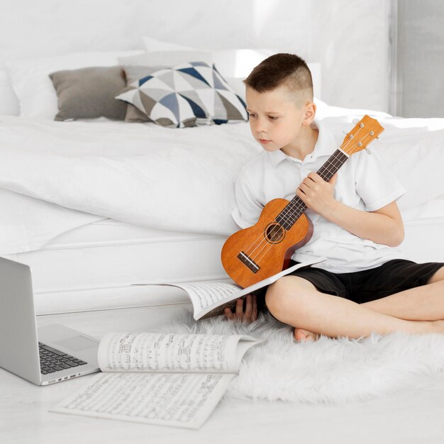Boy holding an ukulele guitar