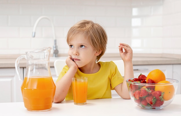 果物を食べるキッチンで自宅の少年