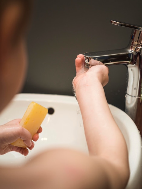 Foto gratuita ragazzo a casa lavarsi le mani