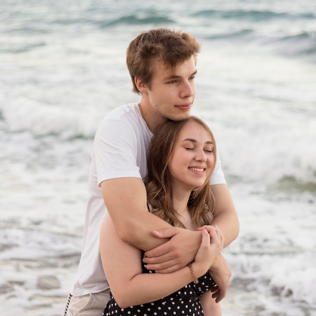 Boy hugging his girlfriend on the beach