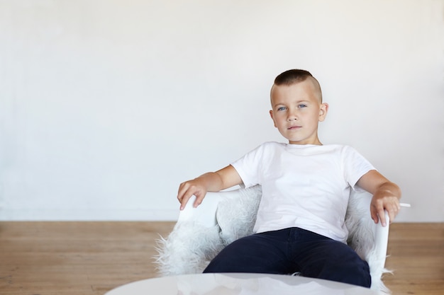 The boy is sitting in the living room