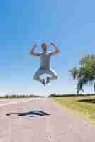 Free photo boy jumping on the road