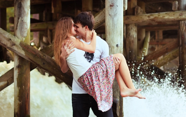 Free photo boy kissing his girlfriend under the dock