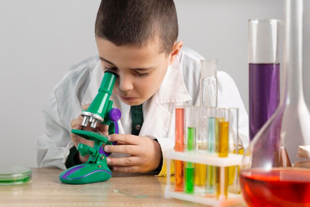 Boy in laboratory with microscope