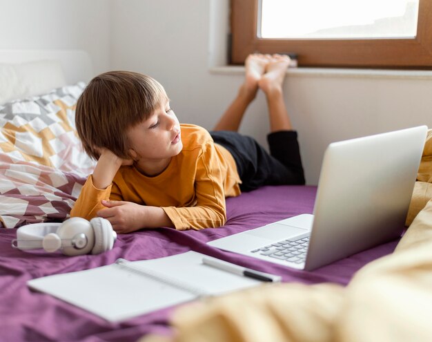 彼のラップトップから学ぶ少年