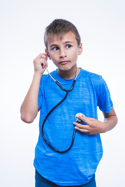 Boy listening to his heartbeat with stethoscope