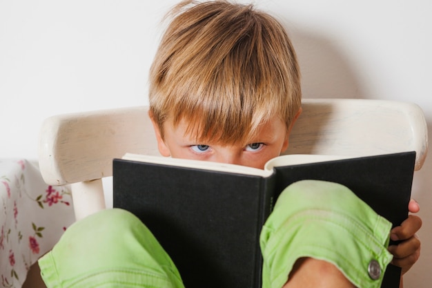 Free photo boy looking over book