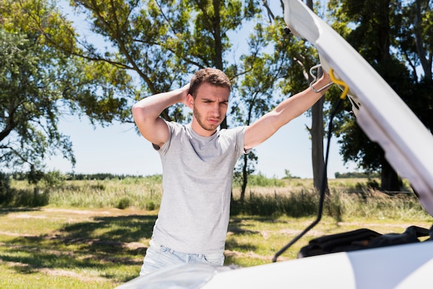 Free photo boy looking at broken down car