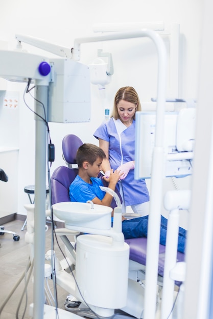 Boy looking at dentist hand in clinic
