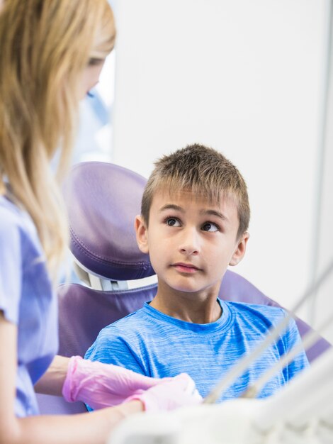 Boy looking at female dentist in clinic