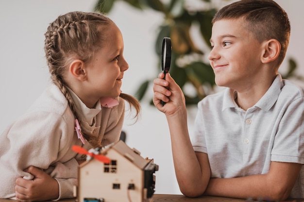 Boy looking at a girl with a magnifier