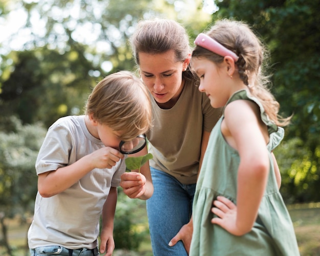 Boy looking at leaves with magnifying glass