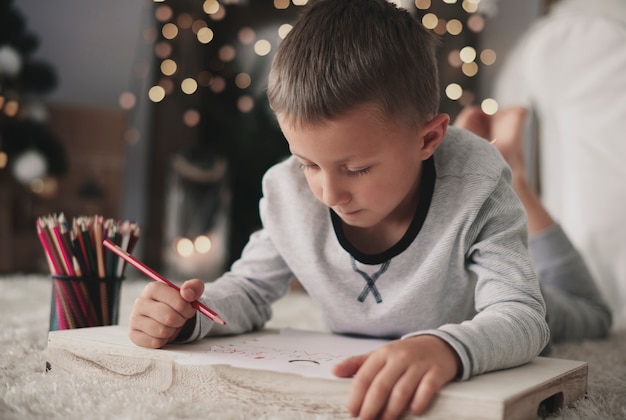 Boy lying on front and drawing