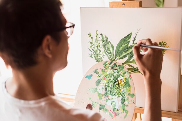 Boy painting on canvas