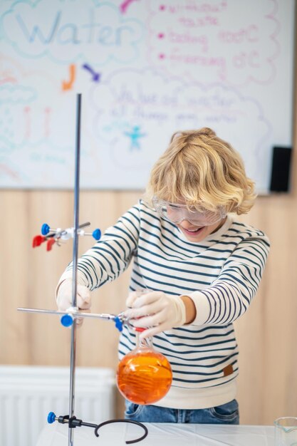 Boy placing test tube on tripod