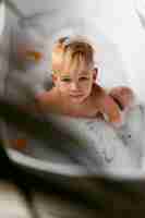 Free photo boy playing in bathtub high angle