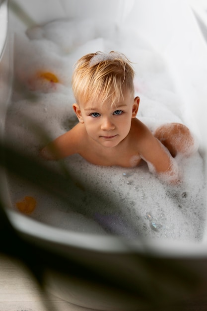 Мальчик играет в ванне под большим углом