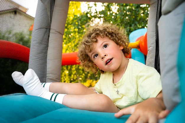 Free photo boy playing in bounce house full shot