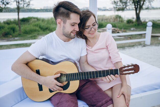 Boy playing guitar to his girlfriend