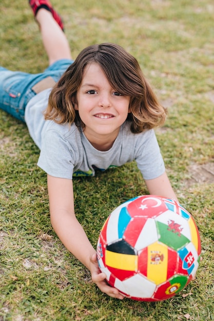 Мальчик играет с мячом на траве