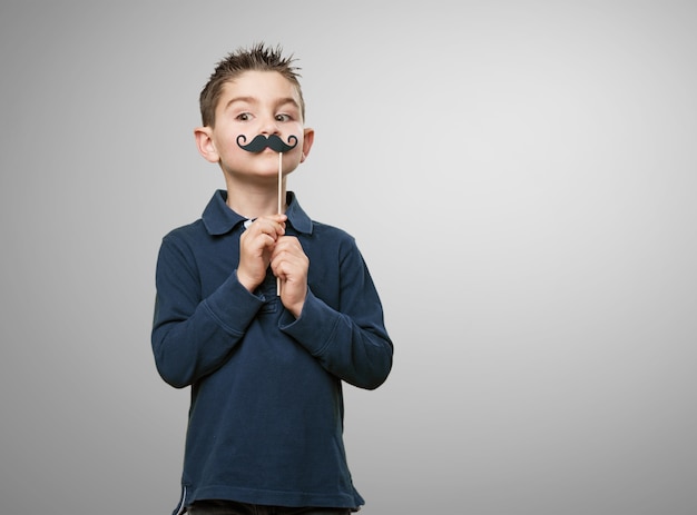 Boy playing with a fake mustache