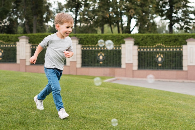 Мальчик играет с мыльными пузырями