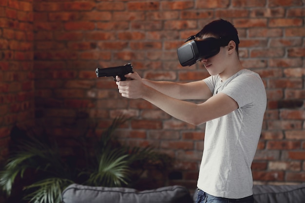 Foto gratuita ragazzo che gioca con la cuffia avricolare di vr a casa