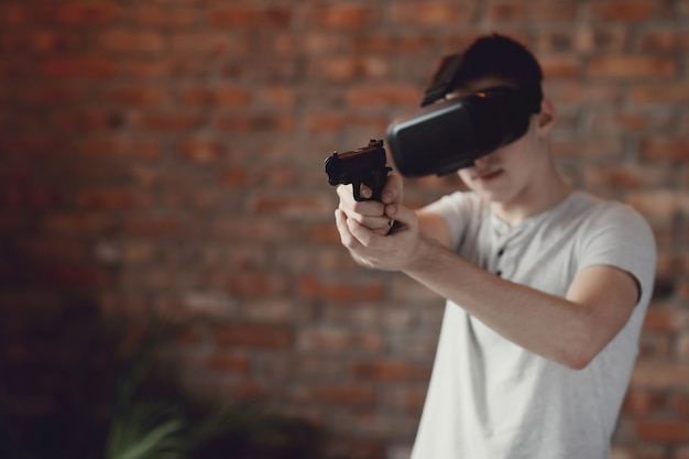 Foto gratuita ragazzo che gioca con la cuffia avricolare di vr a casa