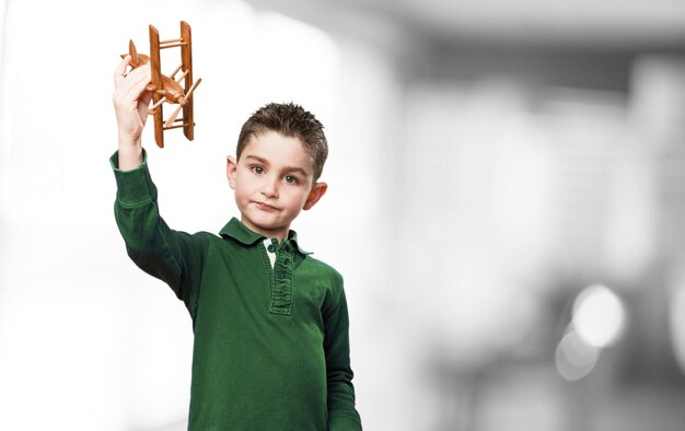 Boy playing with a wooden plane