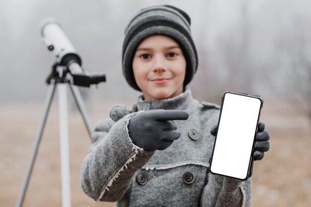 Boy pointing to a blank smartphone
