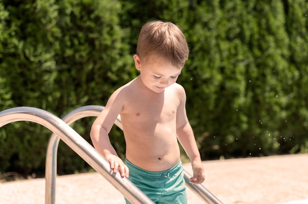 Мальчик на лестнице у бассейна