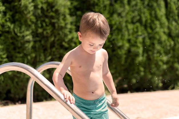 Boy on pool stairs